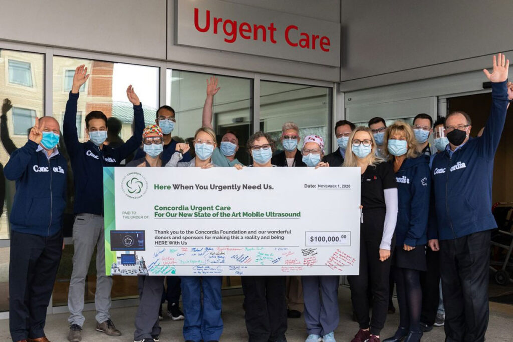 The staff of Urgent Care holding a giant check for 0,000